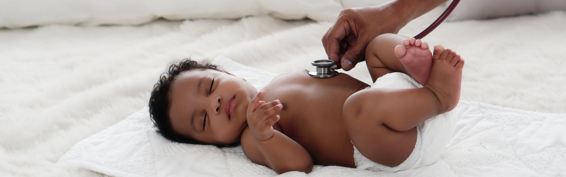 baby girl being checked up with a stethoscope