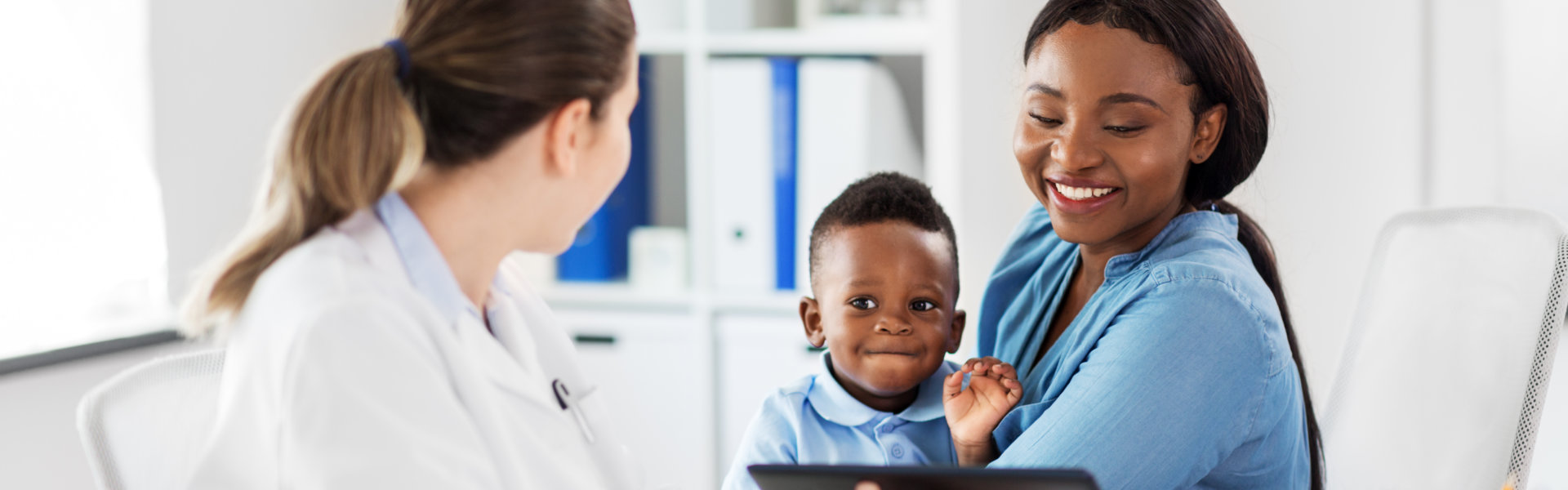 mother carrying her son while talking to the doctor