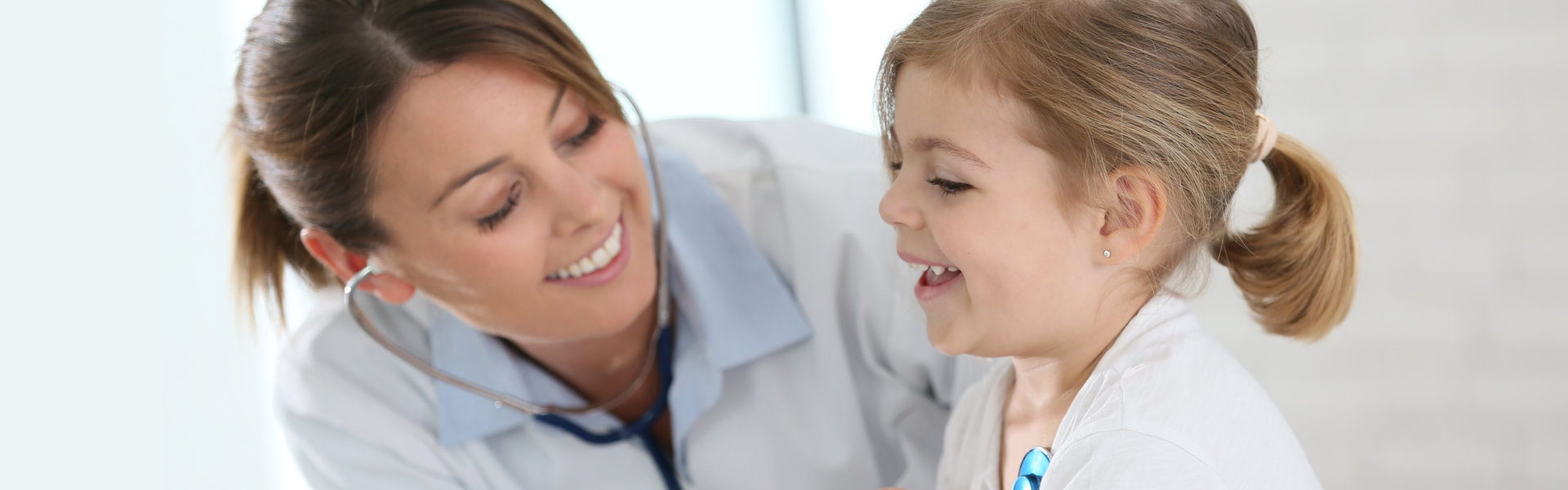 doctor examining little girl with stethoscope